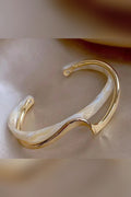 Pulsera dorada con ópalo blanco