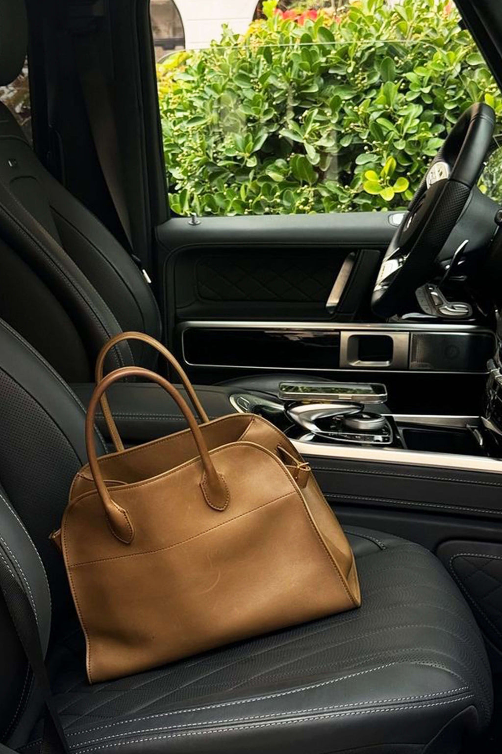 El bolso tote Harlow apoyado en el asiento de un coche