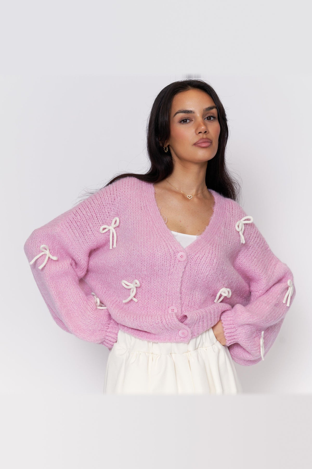 Cárdigan oversize con lacitos en rosa con lazos blancos