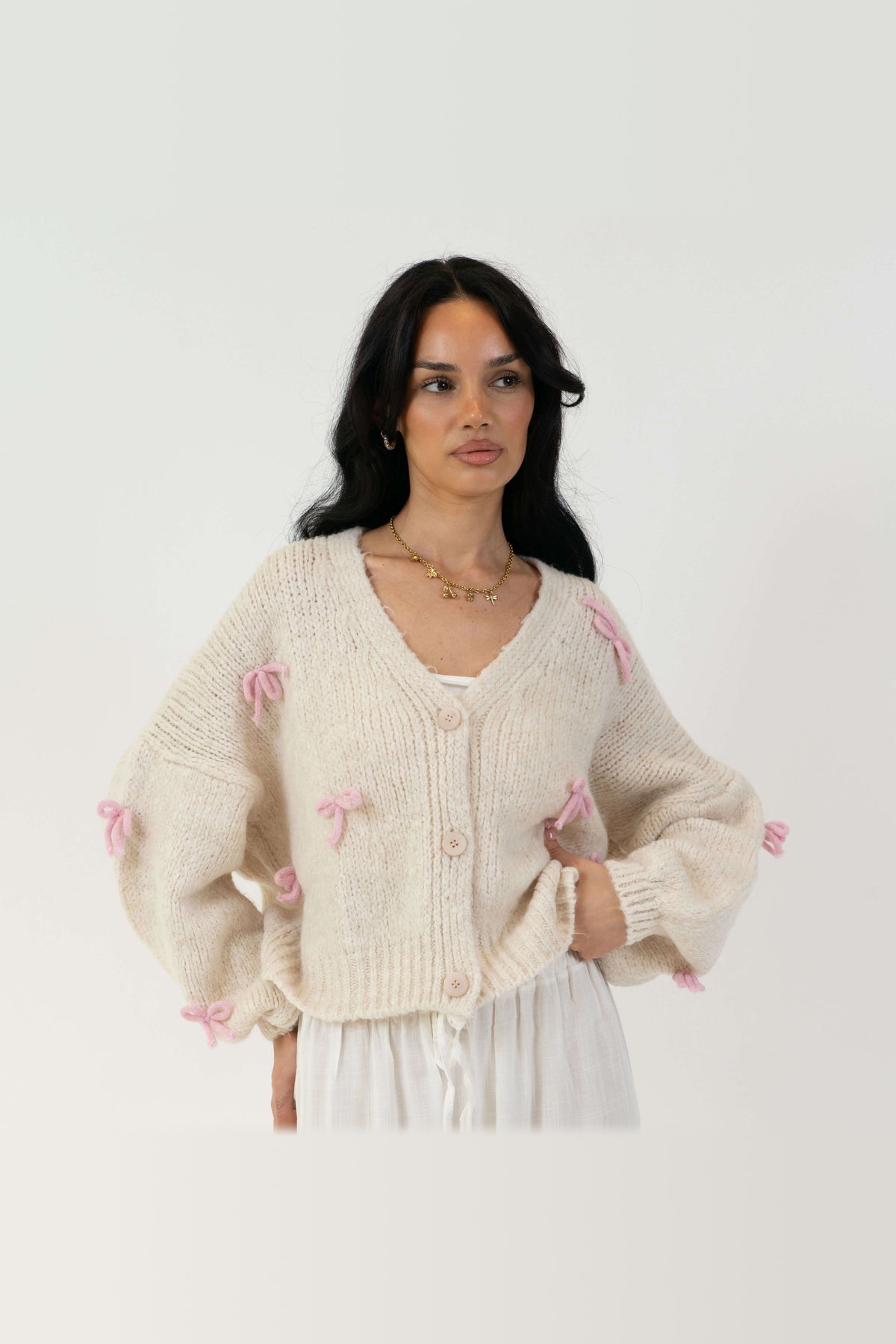 Cárdigan oversize con lacitos en crema con lazos rosa