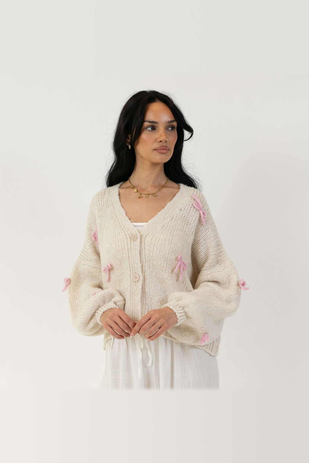 Cárdigan oversize con lacitos en crema con lazos rosa