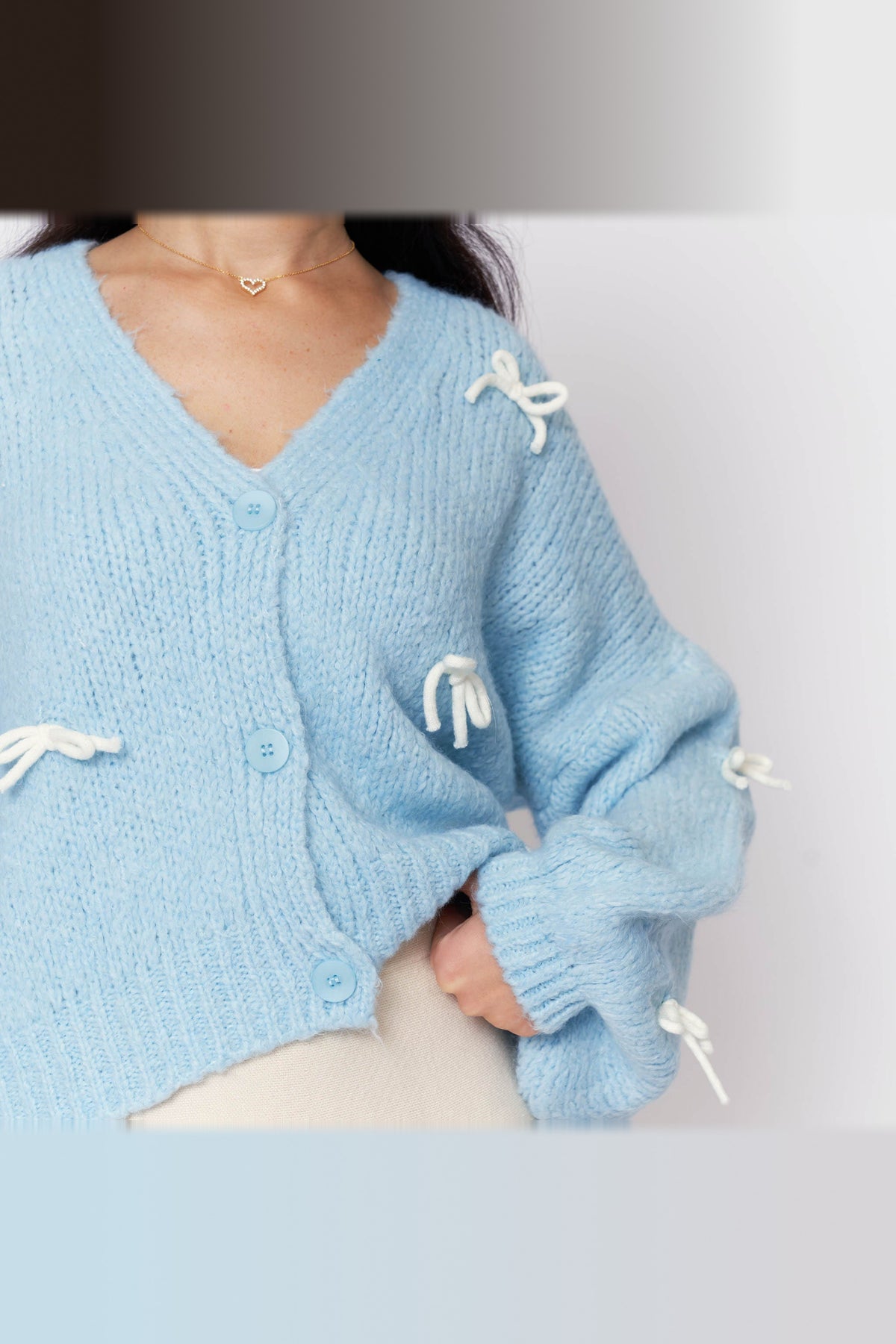 Cárdigan oversize con lacitos en azul bebé con lazos blancos