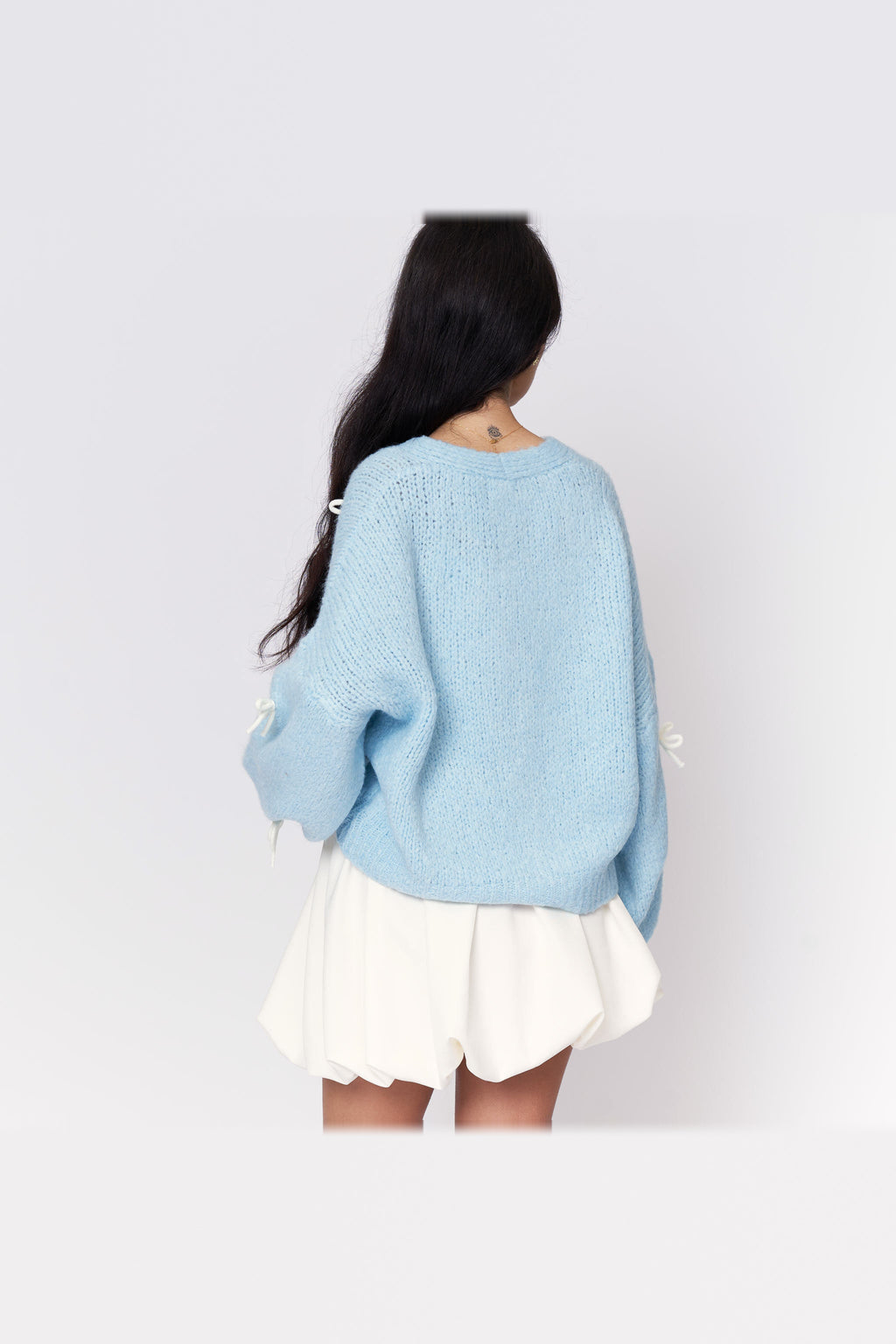 Cárdigan oversize con lacitos en azul bebé con lazos blancos