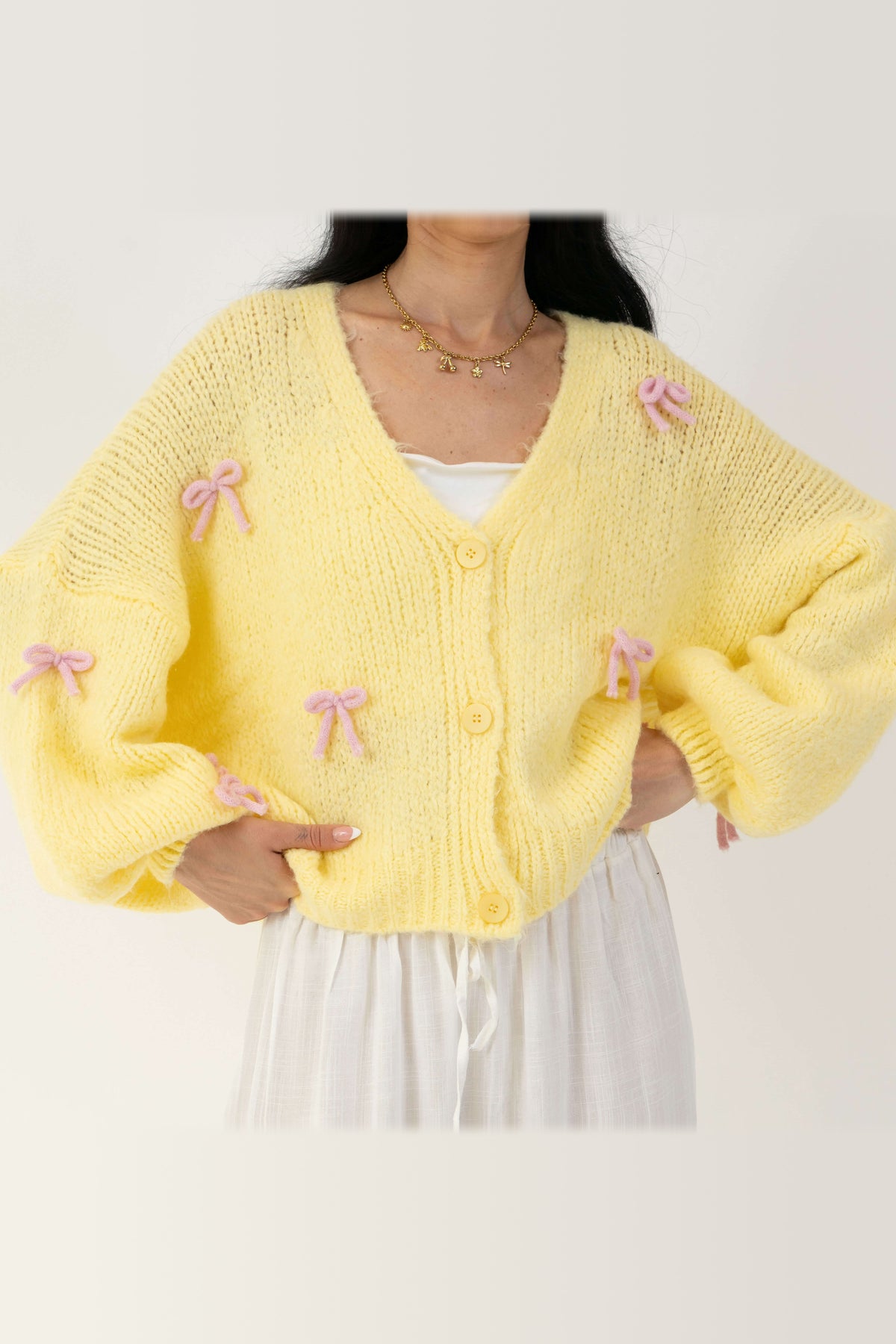 Cárdigan oversize con lacitos en amarillo con lazos rosa