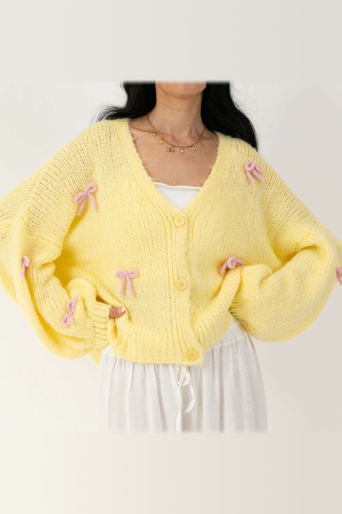 Cárdigan oversize con lacitos en amarillo con lazos rosa
